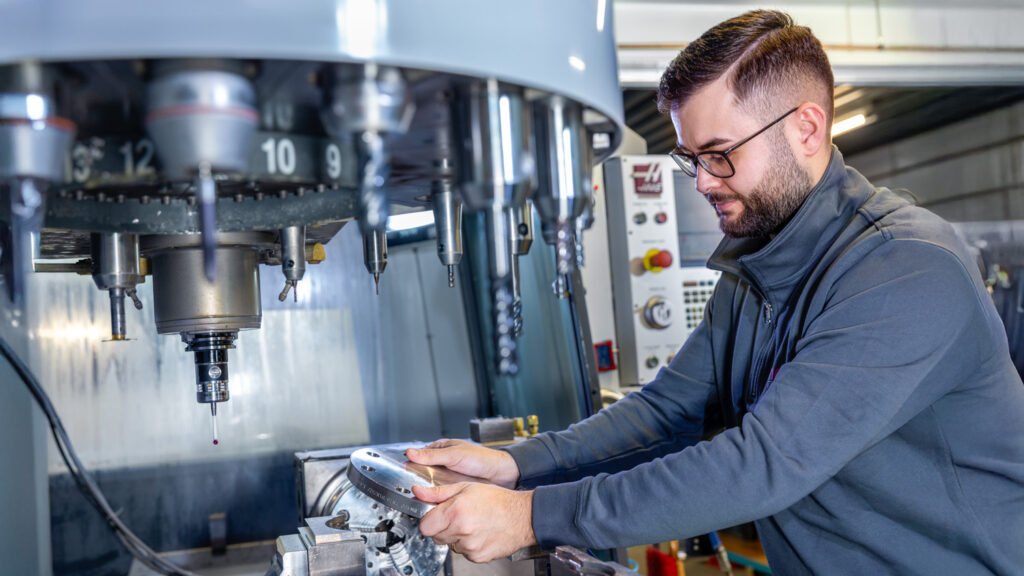 Mitarbeiter arbeitet an einer der 4 CNC Fräs- und Drehmaschinen