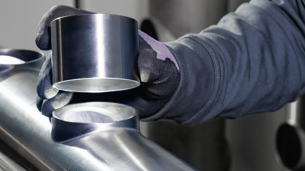 Mitarbeiter bearbeitet ein Vakuumbauteil – das Aushalsen sorgt für nahtlose, strömungsgünstige Übergänge ohne harte Kanten.